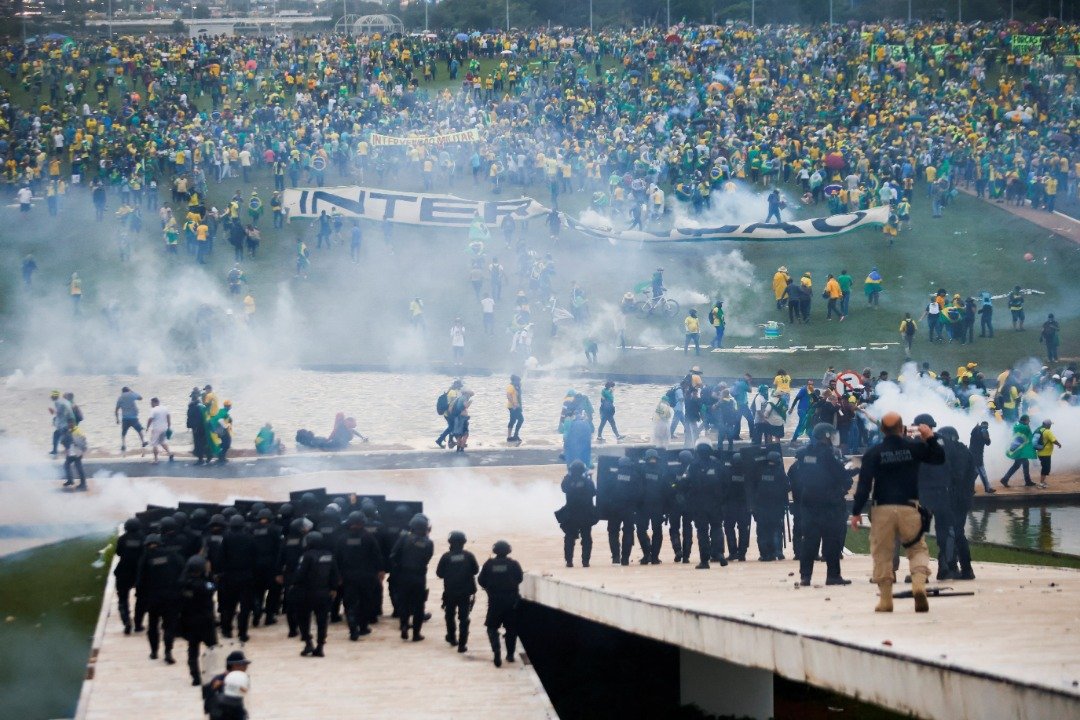 在巴西国会大楼外，安全部队人员向示威者发射催泪弹。（图取自路透社）
