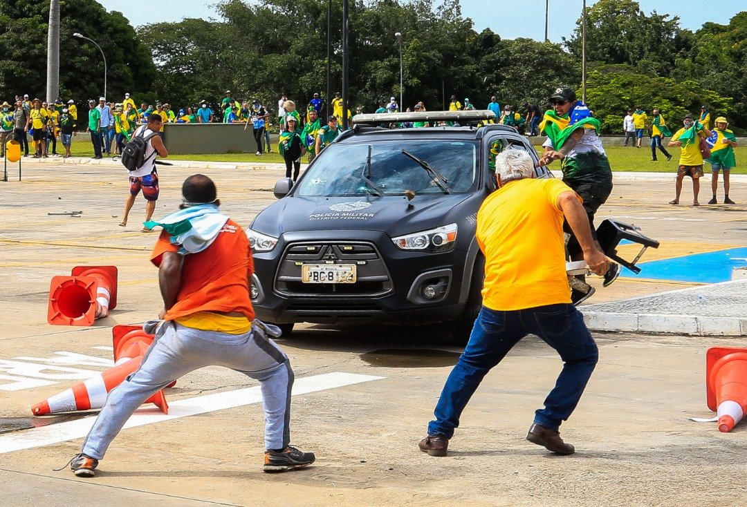 在普拉纳托宫（总统府）外，博索纳罗的支持者攻击一辆宪兵的车辆。（图取自法新社）