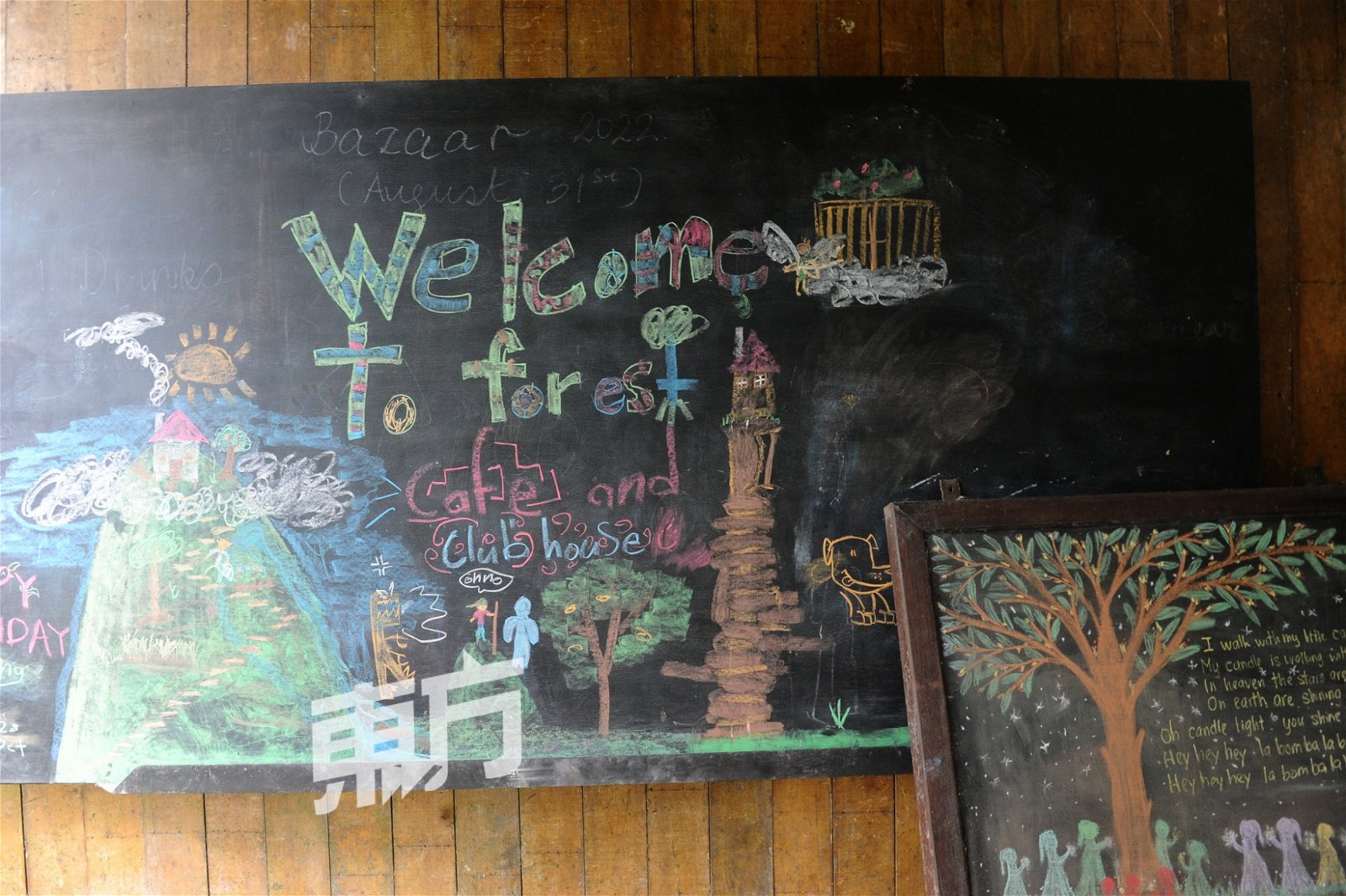 学生们将闲置空间转换为咖啡馆，并在黑板上画上一幅图迎接客人。