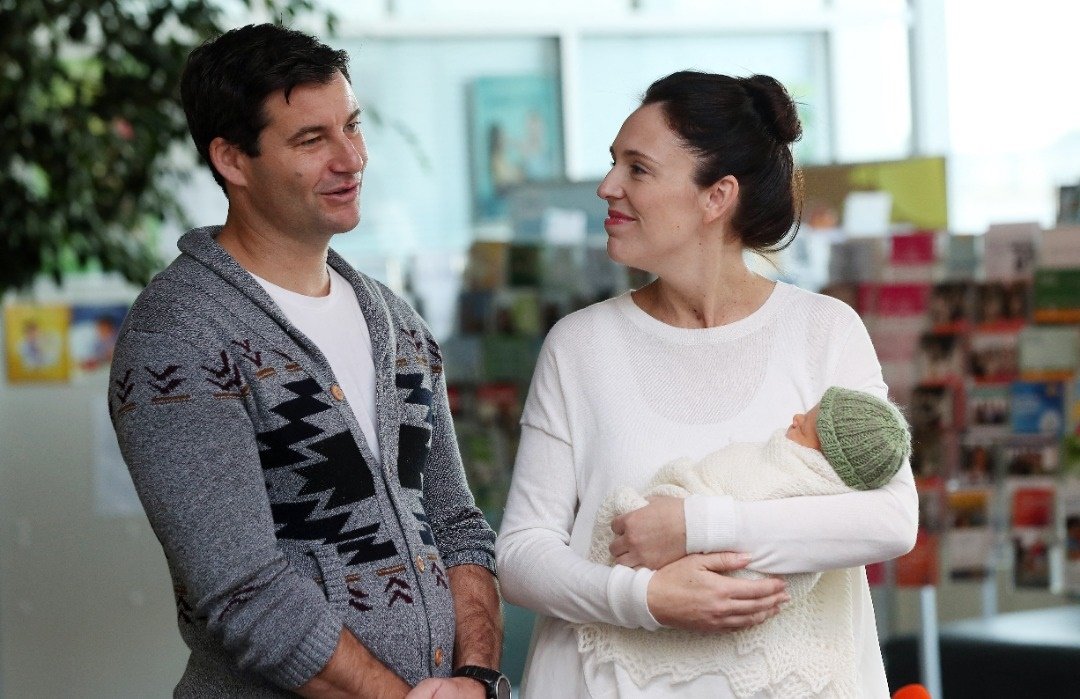 2018年6月24日，纽西兰总理阿德恩（右）和伴侣盖福德与他们新生女儿尼夫在奥克兰医院外合影。（法新社档案照）