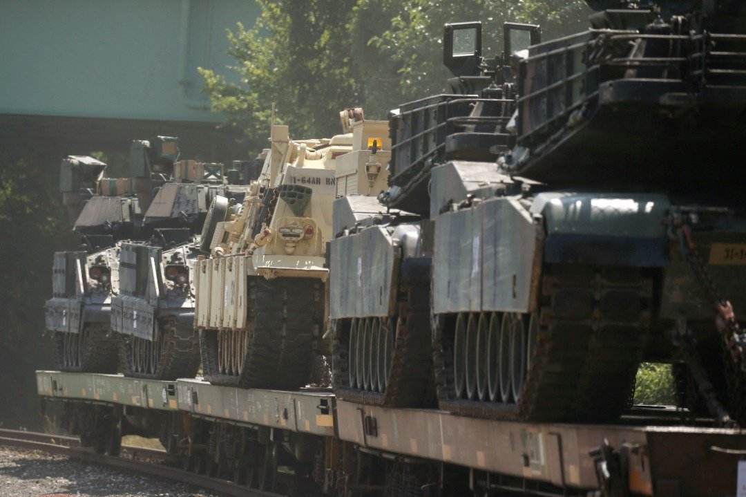M1艾布拉姆斯坦克和其他装甲车在铁路车场的平板车顶上。（图取自路透社档案照）