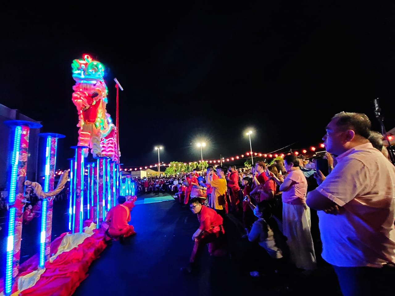 陆兆福（右）与民共同欣赏森州桂青醒狮团呈现LED夜光跳桩表演。