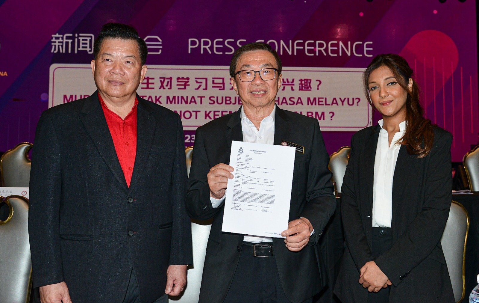 杨安山（左起）、王鸿财和乌玛展示报案书，要求警方以煽动法令调查《每日新闻》和《新海峡时报》。