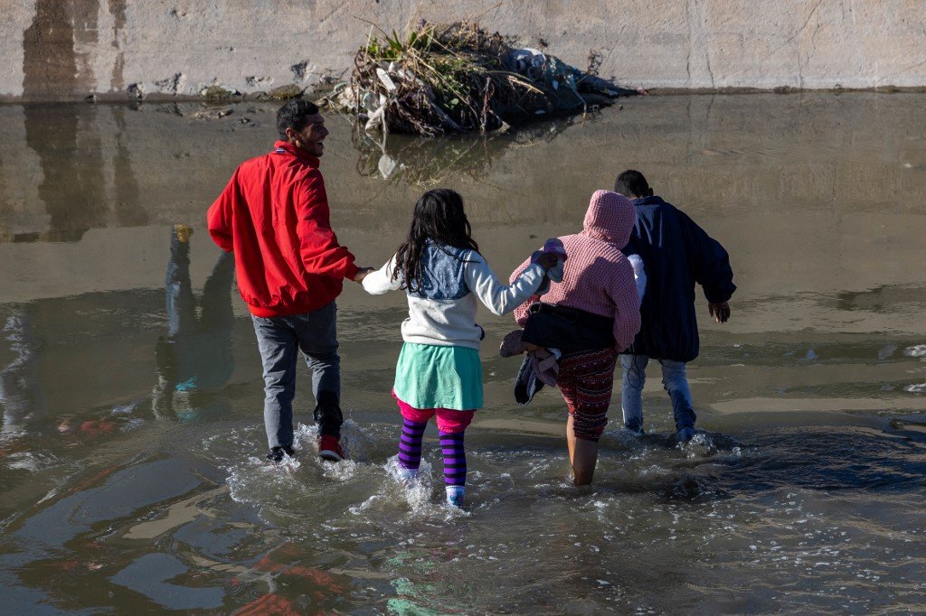 在美国总统拜登造访美墨边境的当天，有大人和小孩移民从墨西哥华雷斯城穿过格兰德河进入得州埃尔帕索。（图取自法新社）