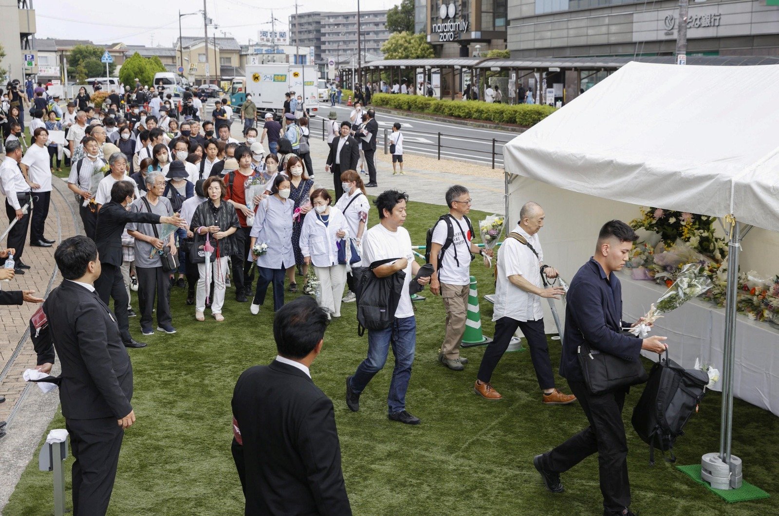民众周六在日本奈良市大和西大寺车站附近排队，以悼念日本前首相安倍晋三逝世一周年。（图取自日本共同社/路透社）