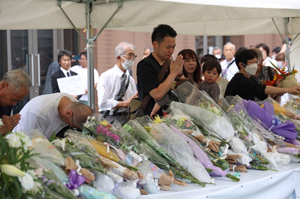周六在日本奈良市大和西大寺车站附近，人们在日本前首相安倍晋三身亡地点献花祈祷。（图取自日本时事通讯社/法新社）