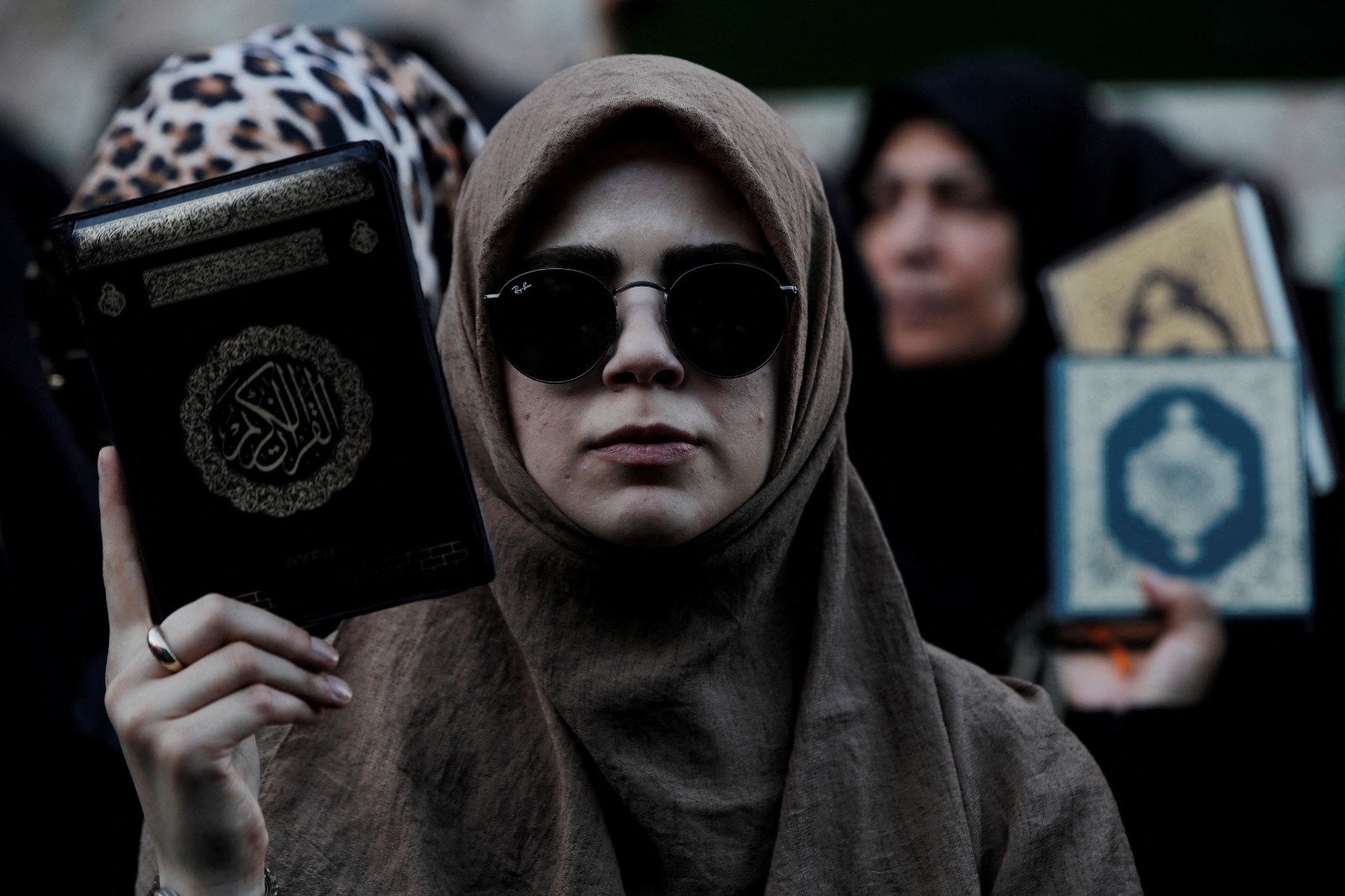 在瑞典驻伊斯坦布尔总领事馆外，土耳其民众手持《可兰经》进行抗议活动。（图取自路透社）