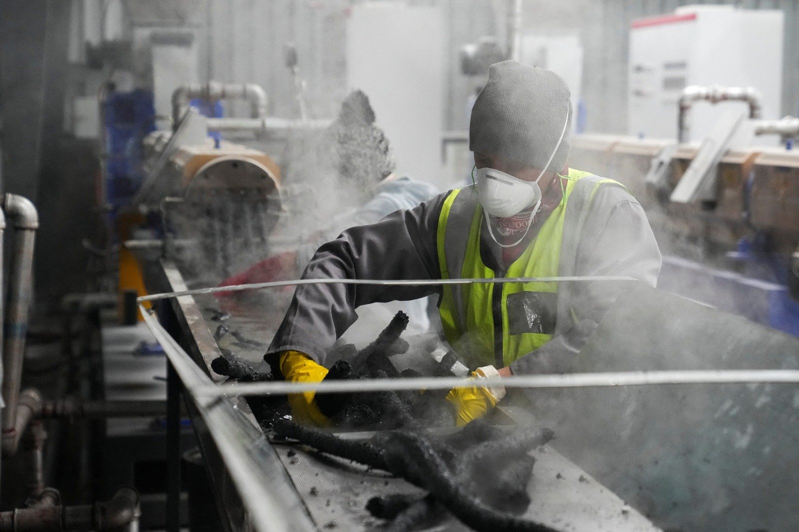 在南非开普敦的一家工厂，工人们在收集由不可回收塑料加工而成的RESIN8 管，用于制造建筑砖。（图取自路透社）