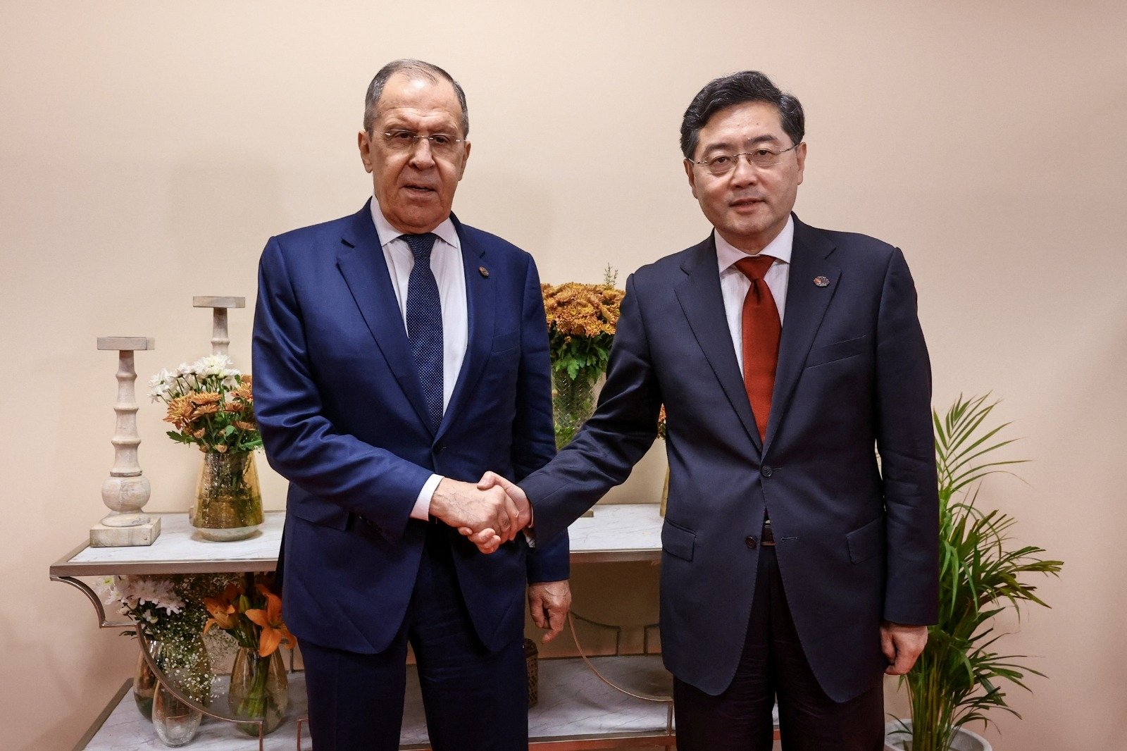 俄罗斯外长拉夫罗夫（左）和中国外长秦刚在新德里G20外长会议相见欢。（图取自俄罗斯外交部\路透社）