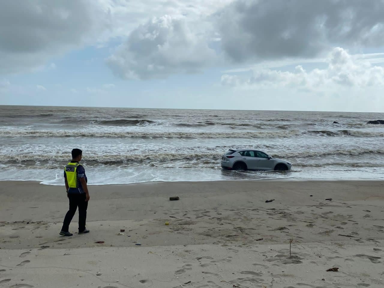 3名男女驾驶的一辆马自达轿车到海边吹海风，却一时没有察觉海水涨潮，险连人带车卷入海中。（瓜拉素里里警局面子书）