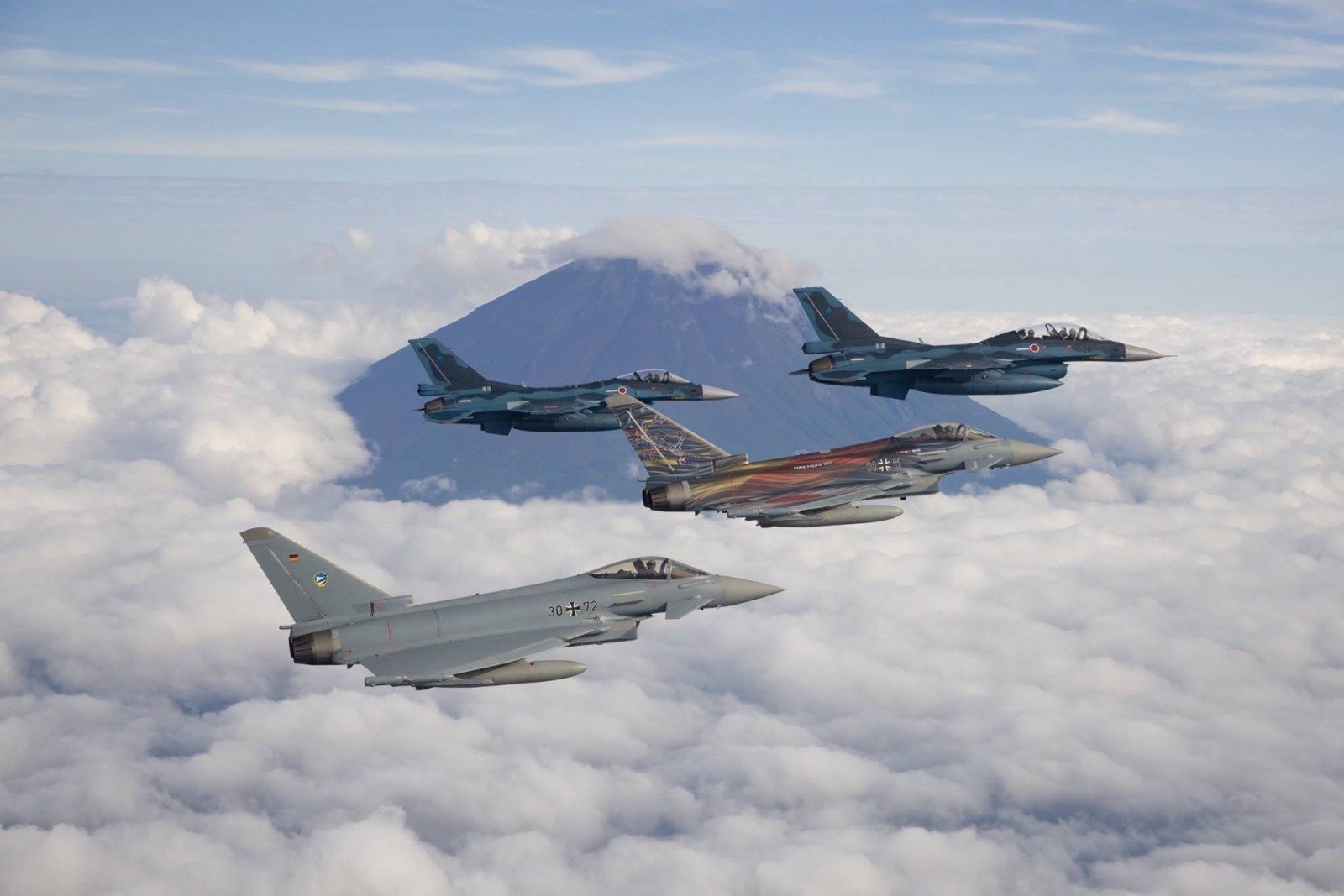 日本F-2战斗机与德国空军战机在去年的联合军事演习期间，飞越日本富士山。（图取自日本防卫部/法新社）