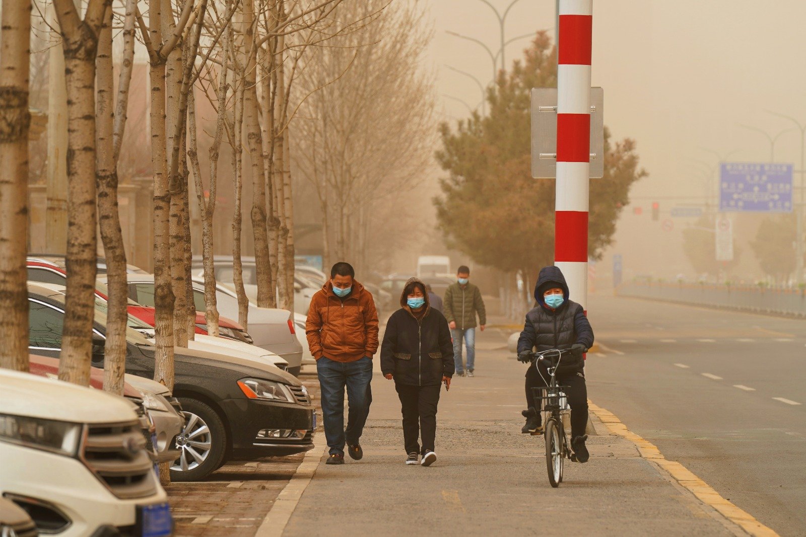 在黑龙江哈尔滨，市民周三在沙尘天气出行。哈尔滨市气象台当天发布沙尘暴黄色预警信号。（图取自中新社）