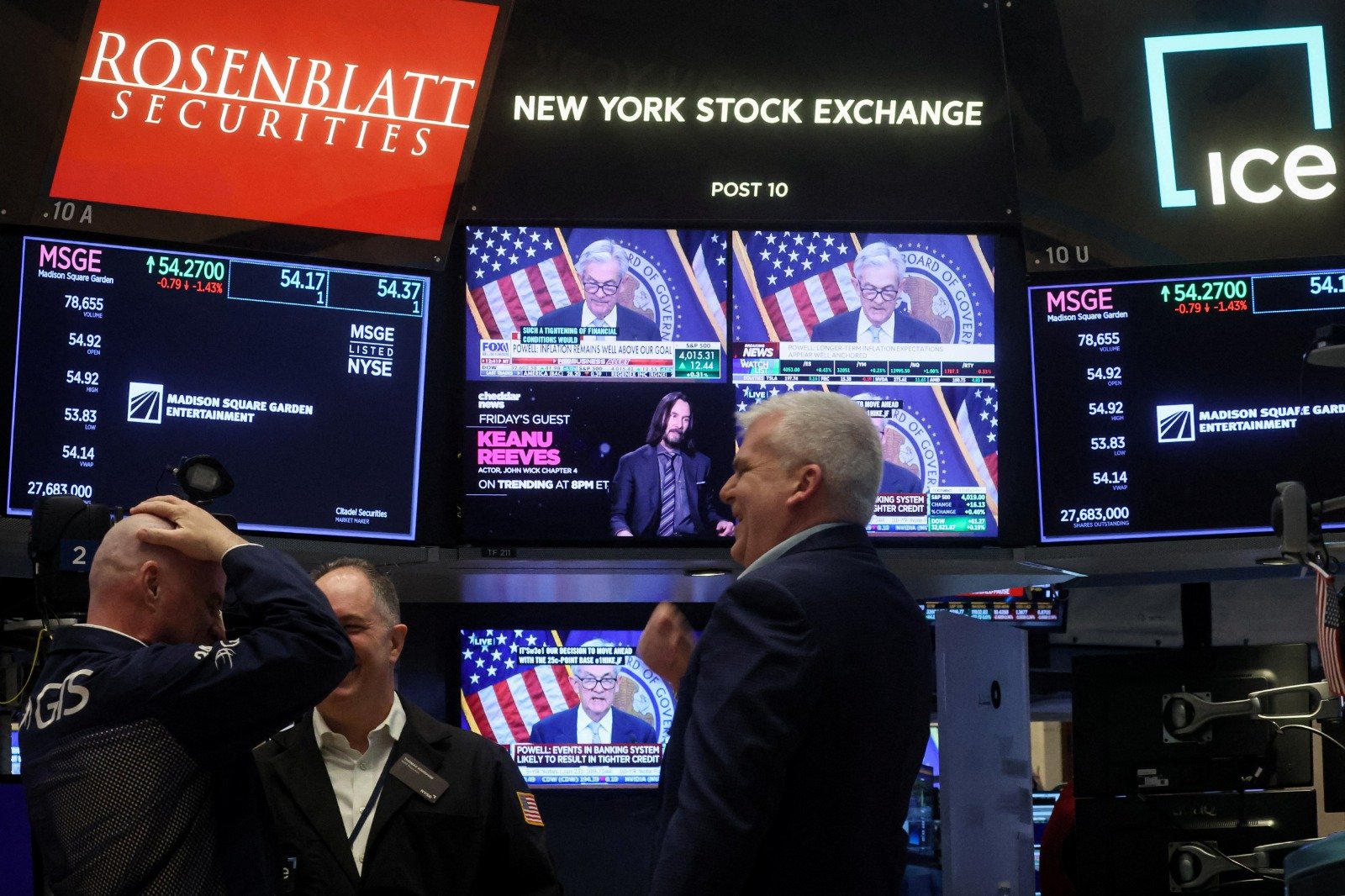 在美国纽约证券交易所 (NYSE) 的屏幕上，播放著美联储委员会主席鲍威尔在新闻发布会上讲话的画面。（图取自路透社）