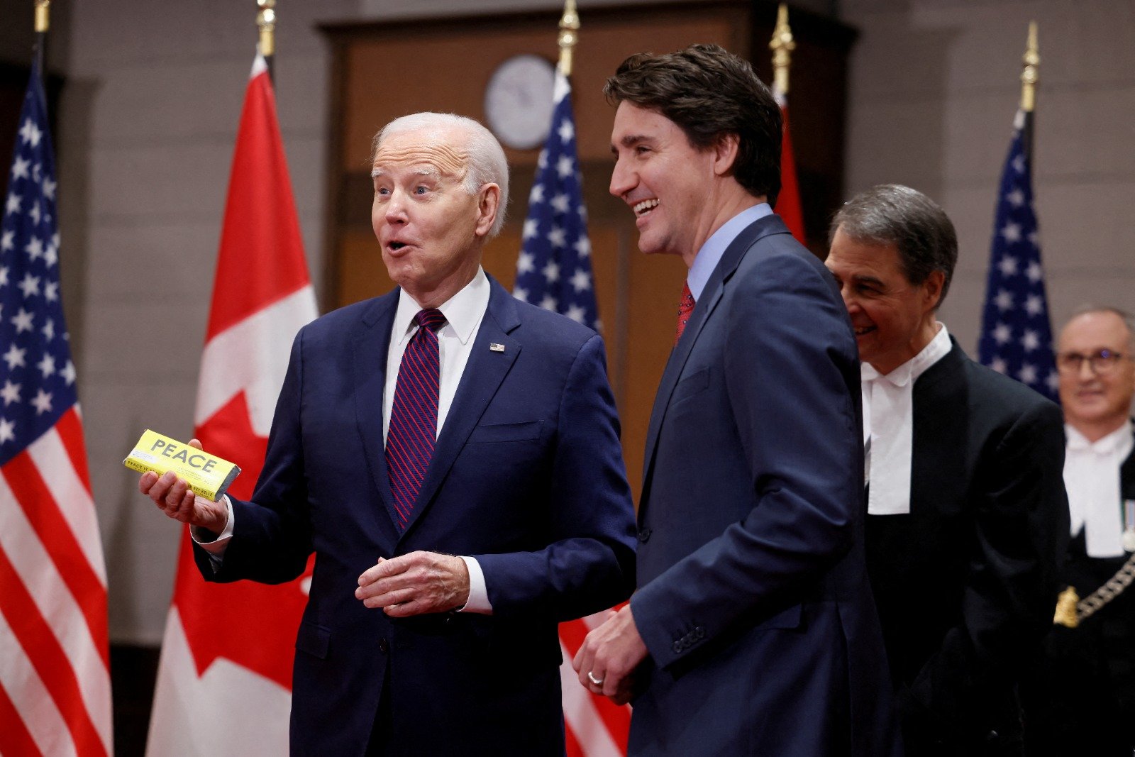 当地时间周五在加拿大渥太华国会山，美国总统拜登（左）收到来自加拿大总理特鲁多的巧克力礼物，露出惊喜的表情。（图取自路透社）