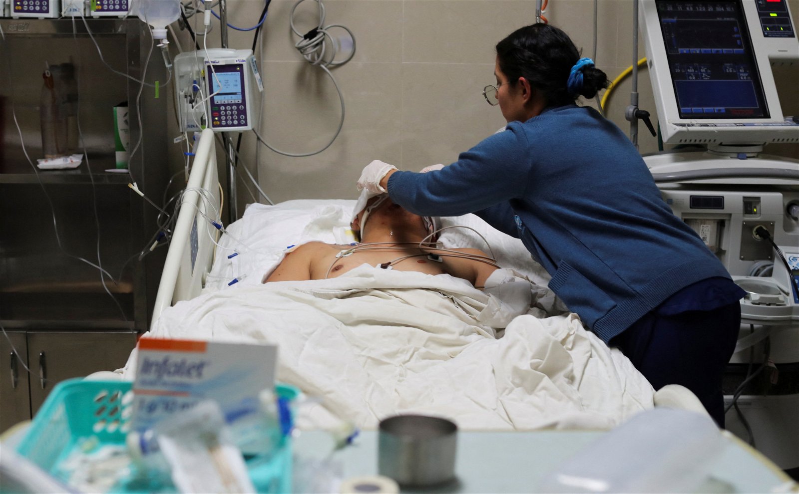 在华雷斯城总医院，一名护士照顾一名在移民拘留中心火灾中受伤的移民。（图取自路透社）