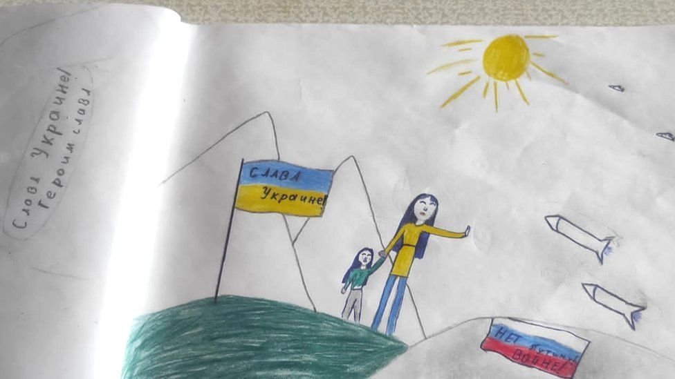 玛莎的画中，俄罗斯导弹如雨般落在一对乌克兰母子身上，还有一面写有“荣耀归乌克兰”的乌克兰国旗，以及一面写上“不要战争”口号的俄罗斯国旗。。（图取自推特）