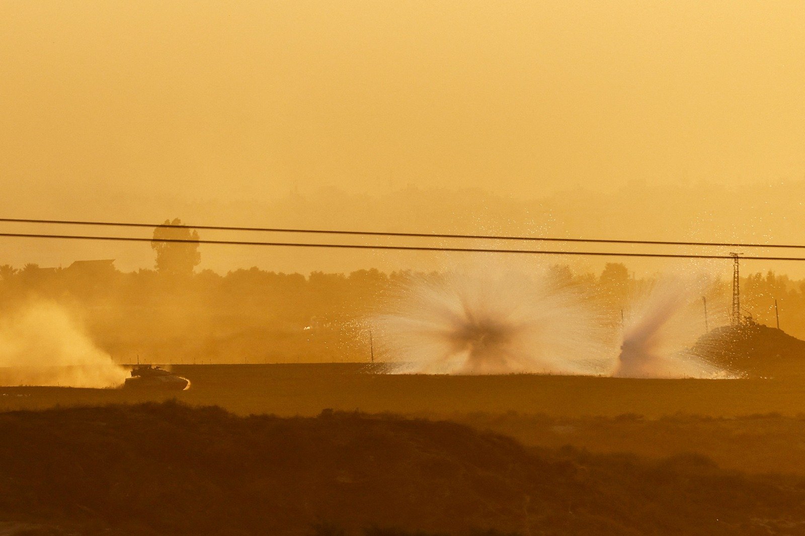 一辆以色列坦克周日走在加沙地带内，前方伴随著爆炸。（图取自路透社）