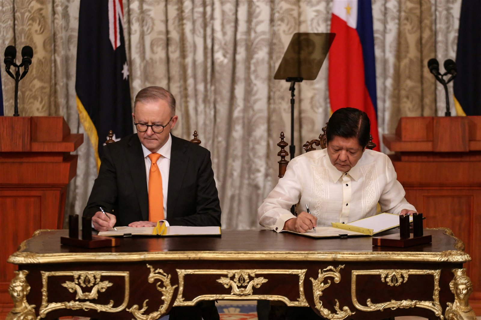 澳洲总理阿尔巴尼斯（左）和菲律宾总统小马科斯，周五在菲律宾马尼拉举行双边会谈期间，签署谅解备忘录。（图取自路透社）
