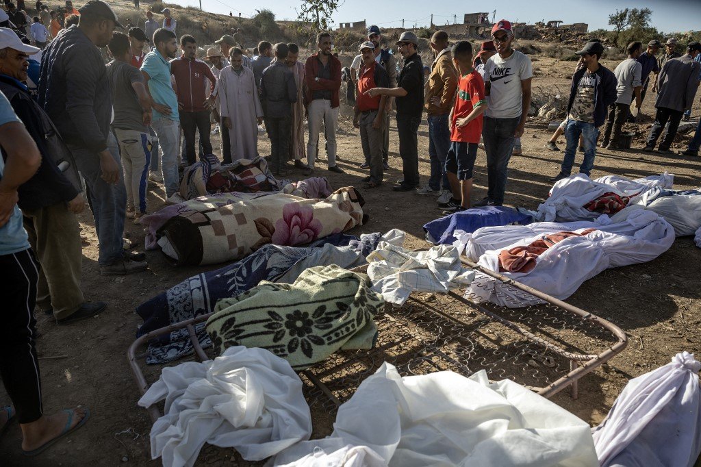 在马拉喀什市西南部的塔菲加特山村，人们聚集在地震遇难者的尸体旁。（图取自法新社）