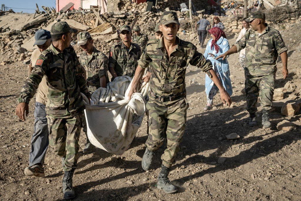 摩洛哥皇家武装部队当地时间周六（9日），从马拉喀什市西南部的塔菲加特山村因地震中被毁的房屋中抬离一具尸体。（图取自法新社）
