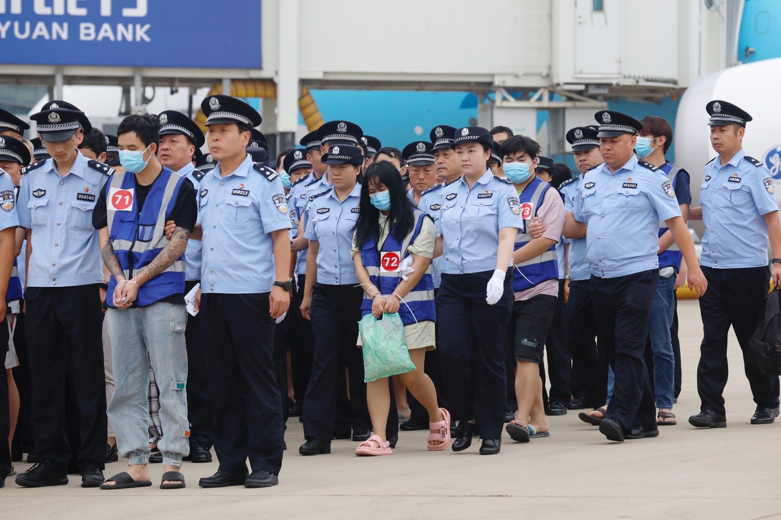 在郑州新郑国际机场，一批电信网络诈骗嫌犯周一下午被河南公安机关从寮国押解回中国。（图取自中新社）