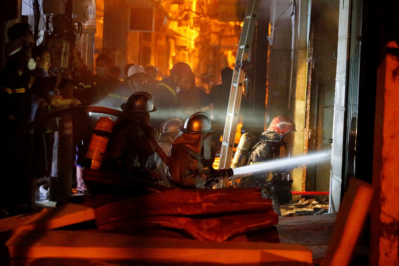 消防员向失火公寓底楼喷水灭火，并试图营救建筑内的居民。（图取自法新社）