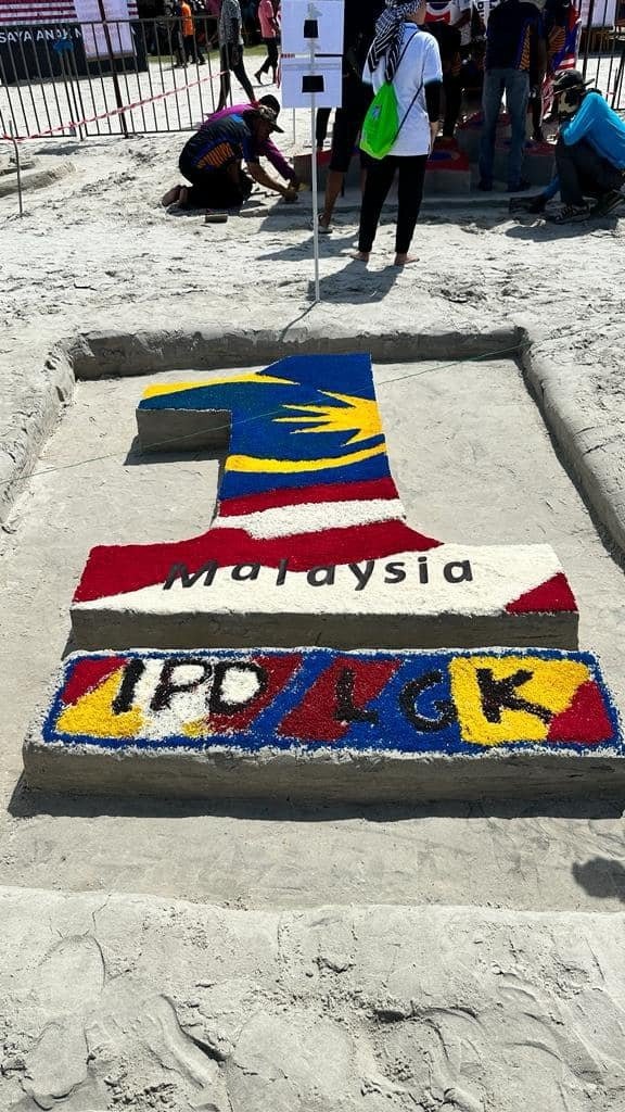 浮罗交怡警方以色彩米粒打造“一个马来西亚”标志的沙雕。