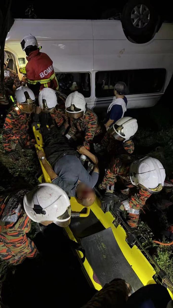 救护员将受困车内的本地司机移出驾座，送往医院治疗。