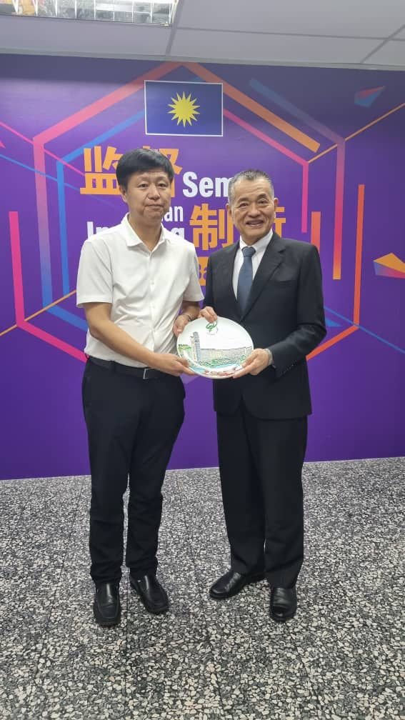 广州大学副校长孙延明（左起）代表赠送纪念品予陈德钦。