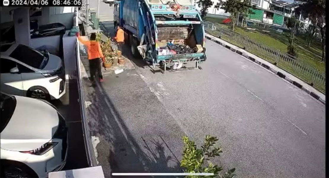 闭路电视画面显示，清洁工友将篱笆墙上的包裹取下，直接丢进垃圾车内。