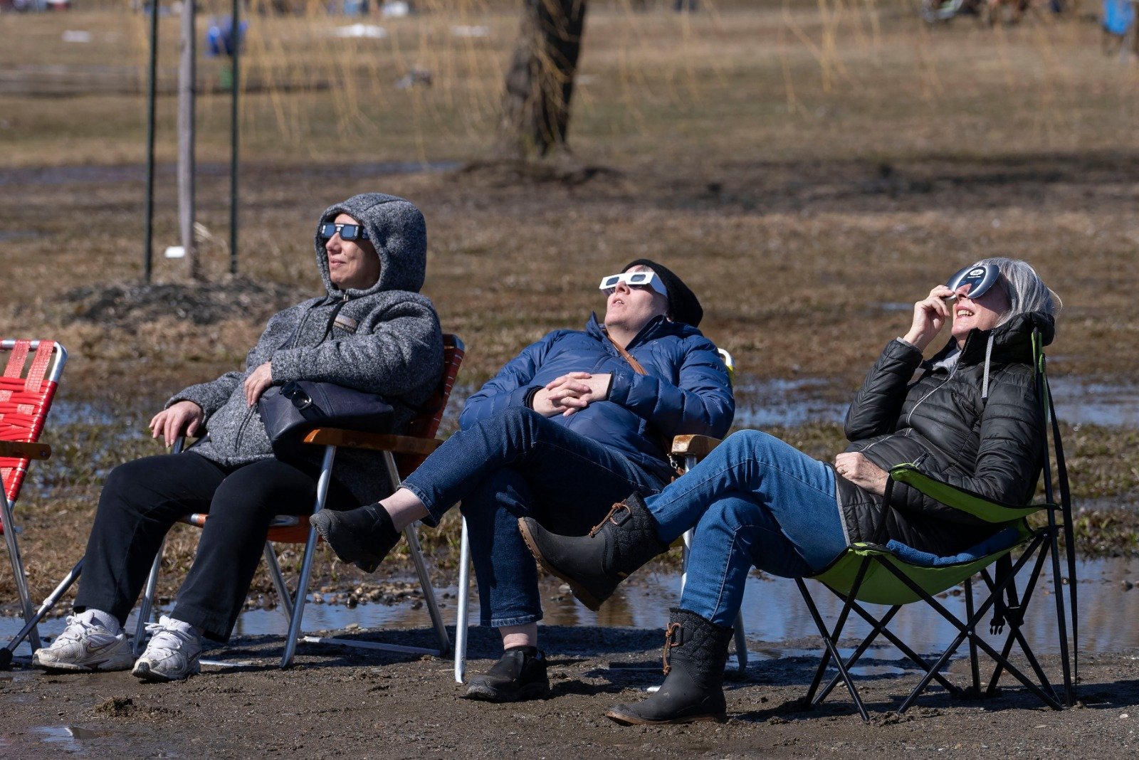 在加拿大魁北克省梅戈格，人们在北美地区的日全食期间抬头仰望太阳。（图取自法新社）