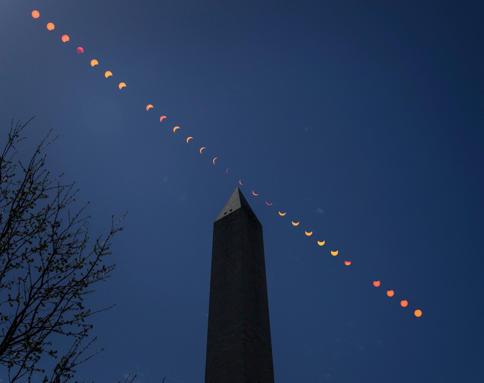 由美国太空总署（NASA）发布照片，显示华盛顿纪念碑上空日偏食的合成图像。（图取自NASA/法新社）