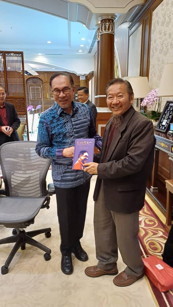 智行学会主席祝家华博士与首相安华会面后赠书合影。