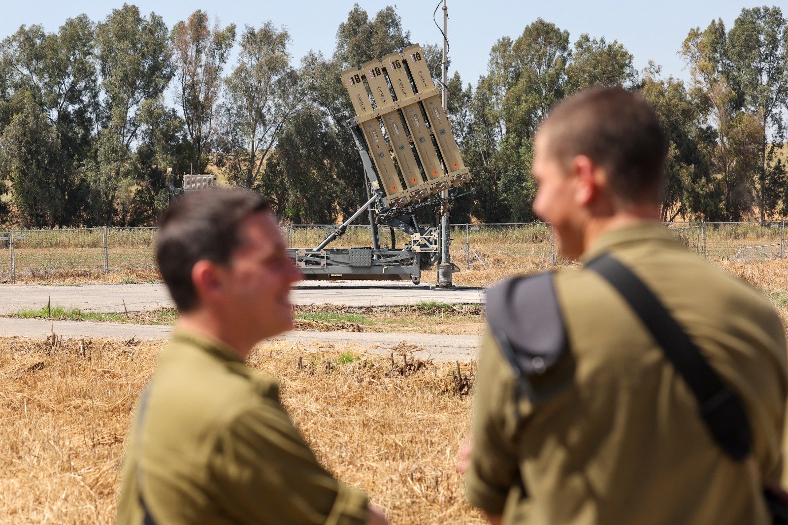 周三在以色列南部与加沙地带边境拍摄的照片，显示以色列士兵站在部署在巴勒斯坦领土附近的“铁穹”防空系统炮台附近。（图取自法新社）