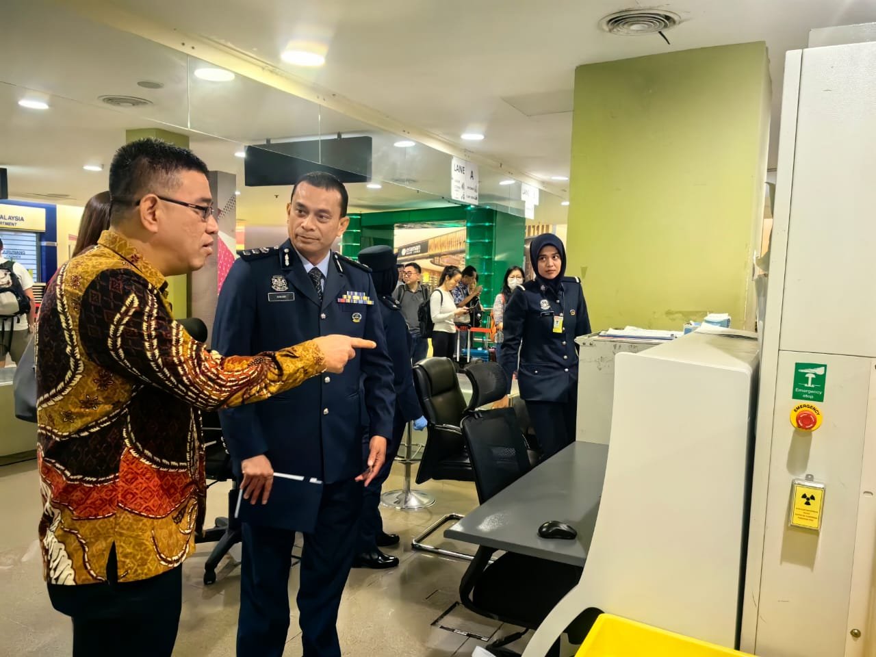 黄汉伟（左）周四到槟城国际机场进行会议，期间向关税局了解行李扫描机器运作。