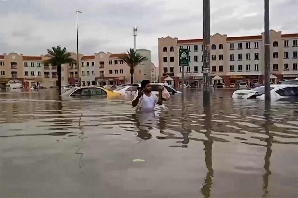 AFPTV周二的这段视频中，一名男子在阿联酋迪拜涉水穿过被洪水淹没的街道。（图取自法新社）
