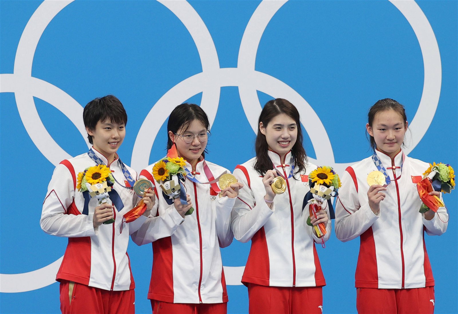 中国泳队选手杨浚瑄、汤慕涵、张雨霏、李冰洁（从左到右）在颁奖仪式上展示手上的金牌。（图取自网络）