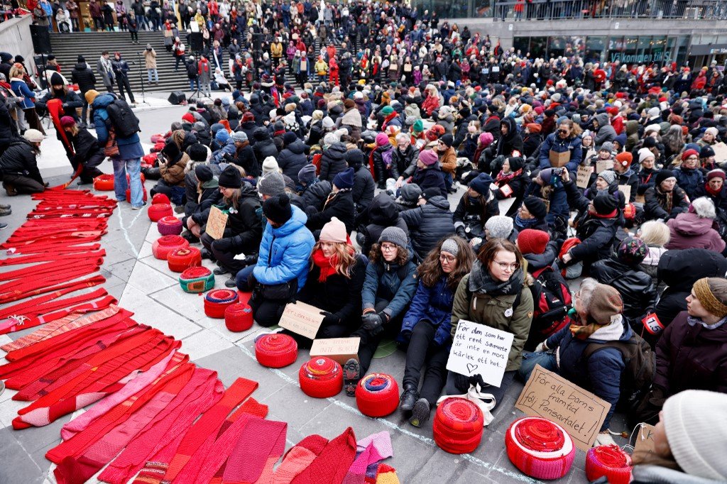 数百名妇女用长长的针织红色围巾包围了瑞典议会大厦，抗议政府对全球暖化问题不作为。（图取自法新社）