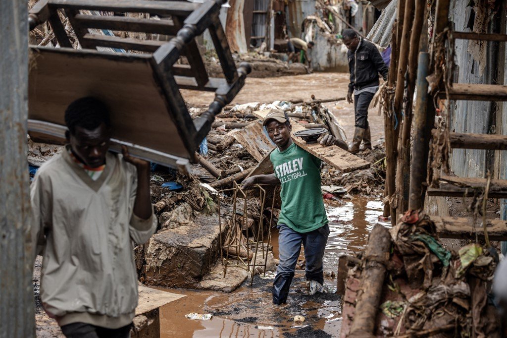 周四在肯尼亚首都内罗毕马萨雷贫民窟，暴雨引发洪水冲毁了房屋，当地居民在水退后清理被摧毁的家园。（图取自法新社）
