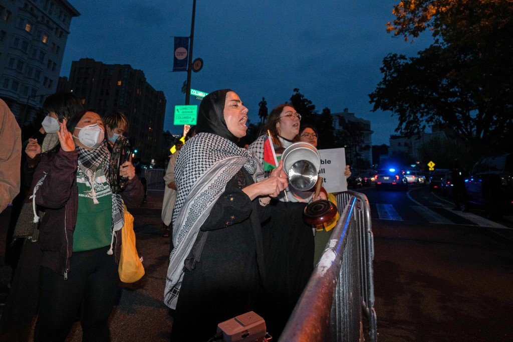 示威者披上巴勒斯坦传统的阿拉伯巾，不满拜登政府处理以巴战争及西方媒体的相关报导。（图取自法新社）