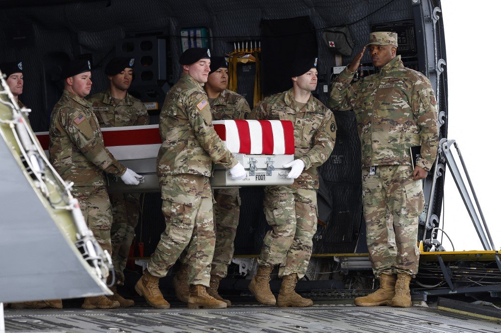 美国陆军在多佛空军基地转移一个挂有美国旗帜、装有3名殉职士兵遗体的箱子。（图取自法新社）