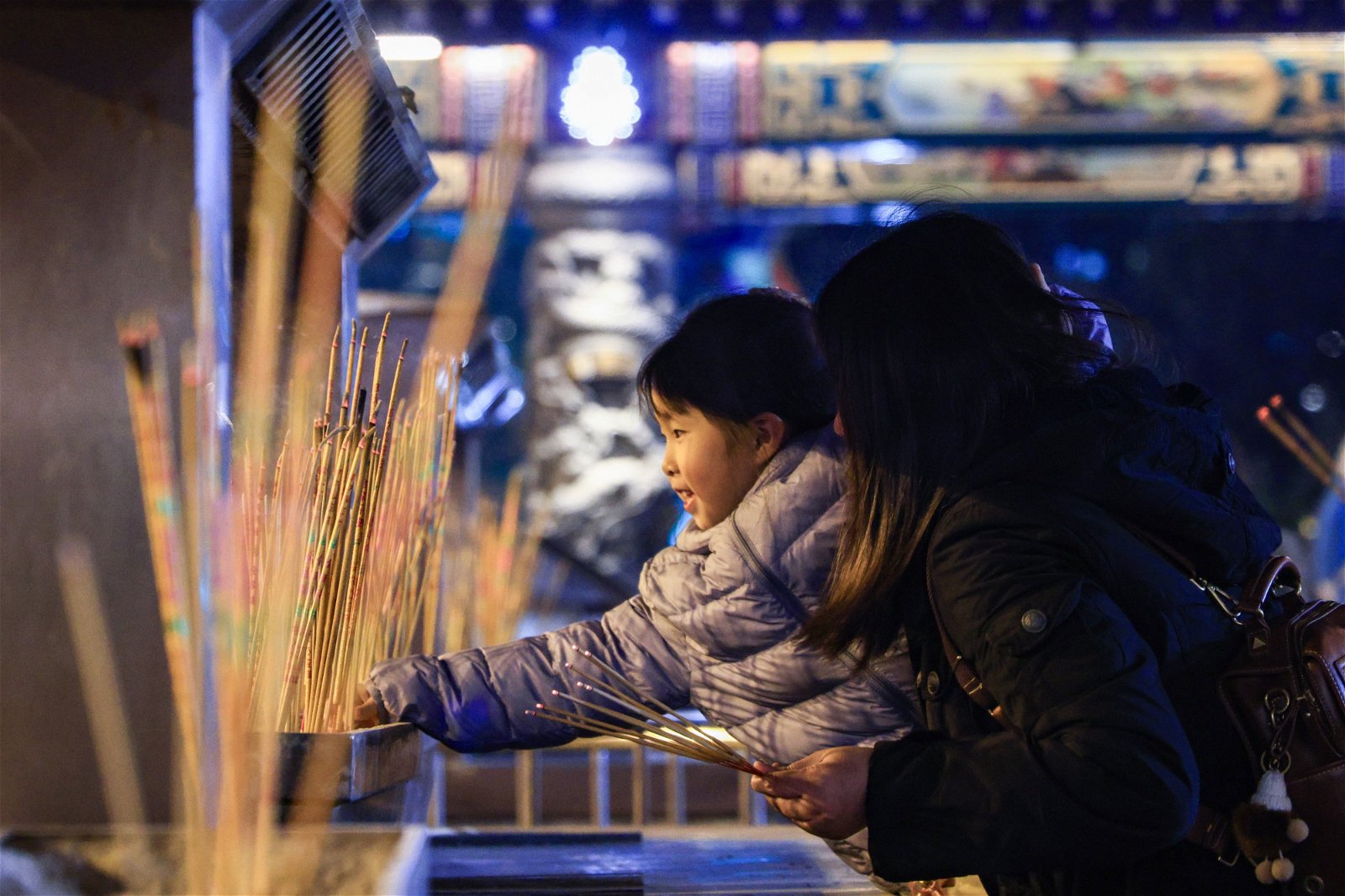 市民带孩子到黄大仙祠上头炷香，体验这个历史悠久的传统习俗。（图取自香港中通社）
