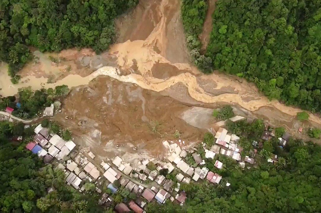 高空航拍图像显示，金达沃省一座金矿山发生山体滑坡后，房子和矿工车辆遭掩埋。（图取自法新社）