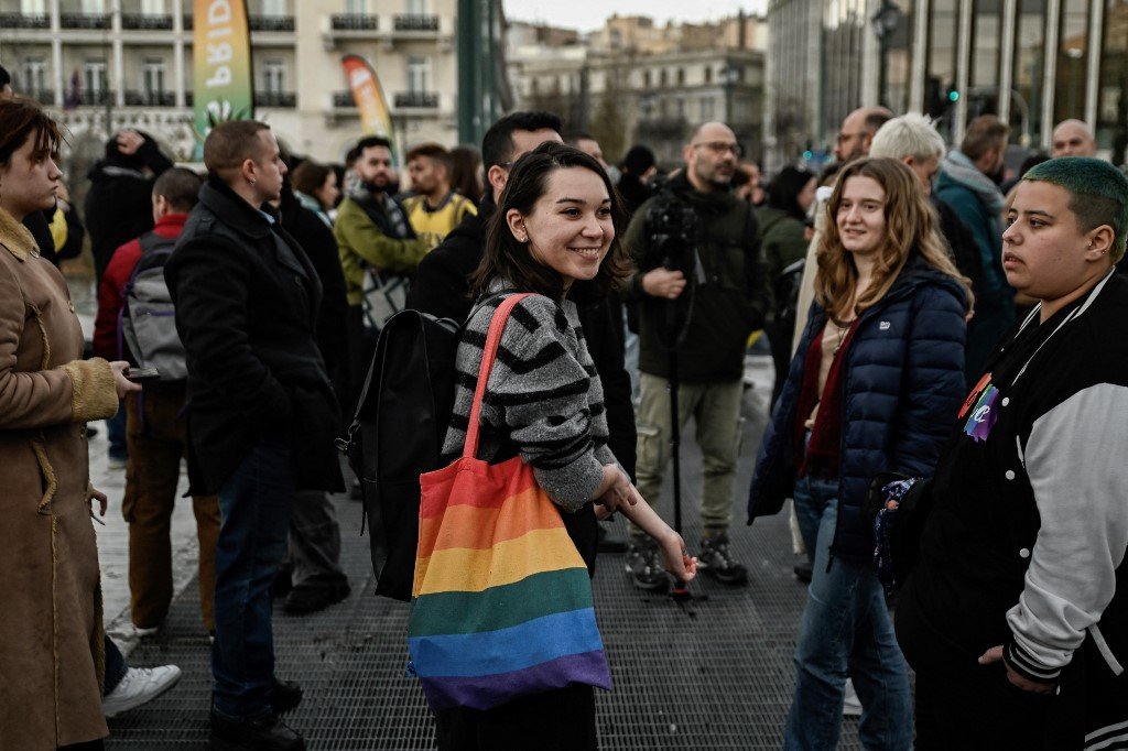当地时间周四，希腊议会在雅典就同性婚姻和同性伴侣收养法案进行投票之际，LGBTQ群体的支持者聚集在希腊议会外。（图取自法新社）
