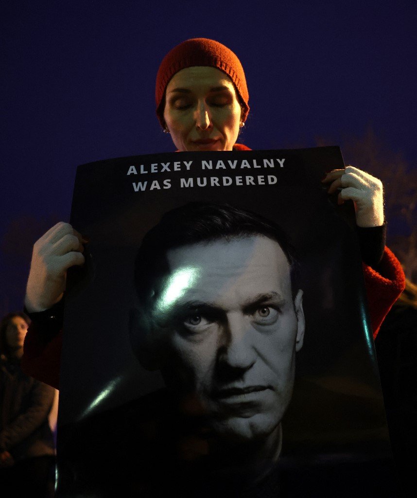 当地时间上周五在华盛顿，在纳瓦尔尼去世后，一批抗议者和哀悼者在俄罗斯大使馆举行悼念集会。一名女子手持纳瓦尔尼肖像照。（图取自法新社）