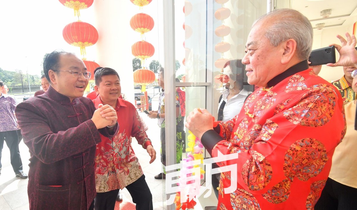 中国驻马大使欧阳玉靖（左）抵达华总大厦出席“华总2024新春大团拜”时，受到华总会长吴添泉（右）欢迎。