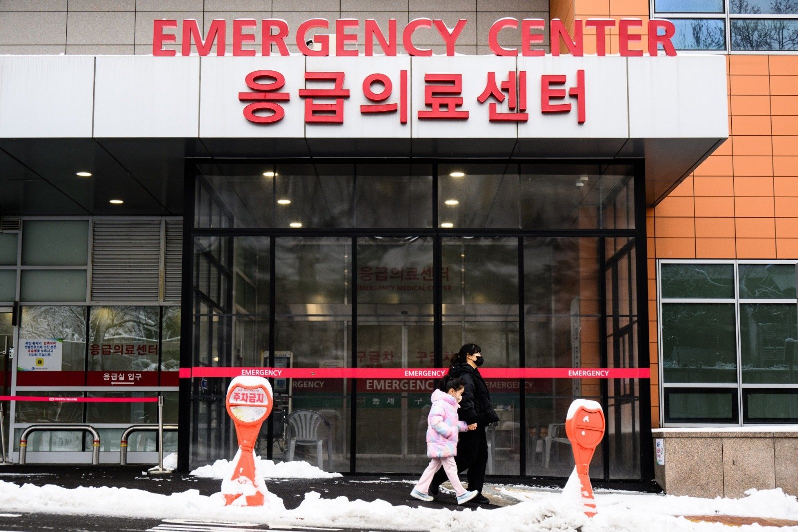 一名妇女和一名儿童周四在首尔一家医院急诊中心外行走。（图取自法新社）
