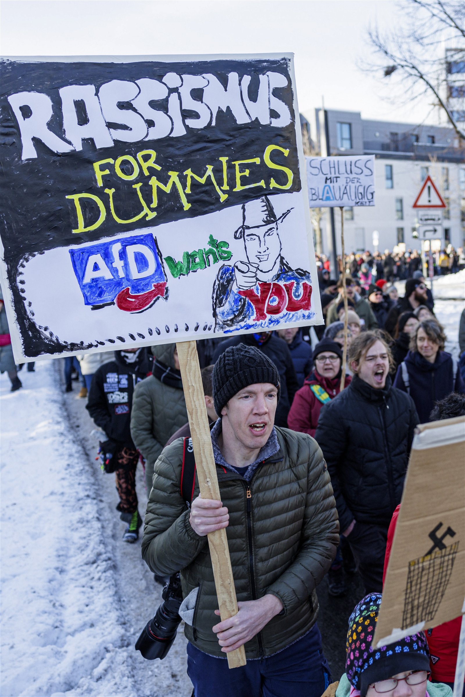 周六在德国中部城市部埃尔福特举行的反对种族主义和右翼极端主义的示威活动中，一名年轻人举著写有“傻瓜种族主义。选择党想要你”的标语牌。（图取自法新社）