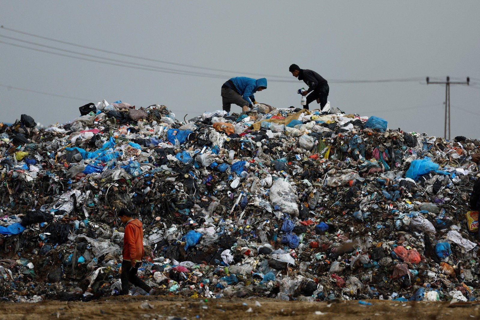 巴勒斯坦人在加沙南部拉法一处垃圾堆中，寻找可用的物资。（图取自路透社）