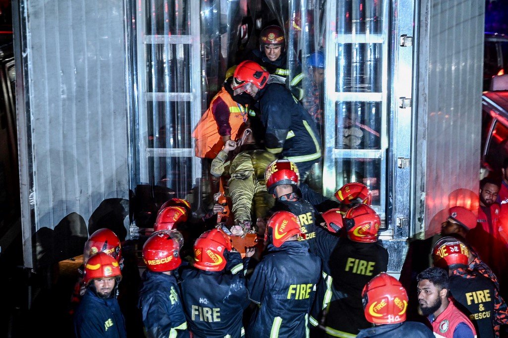 消防队员在火灾的救援行动中擡出一名伤者。（图取自法新社）